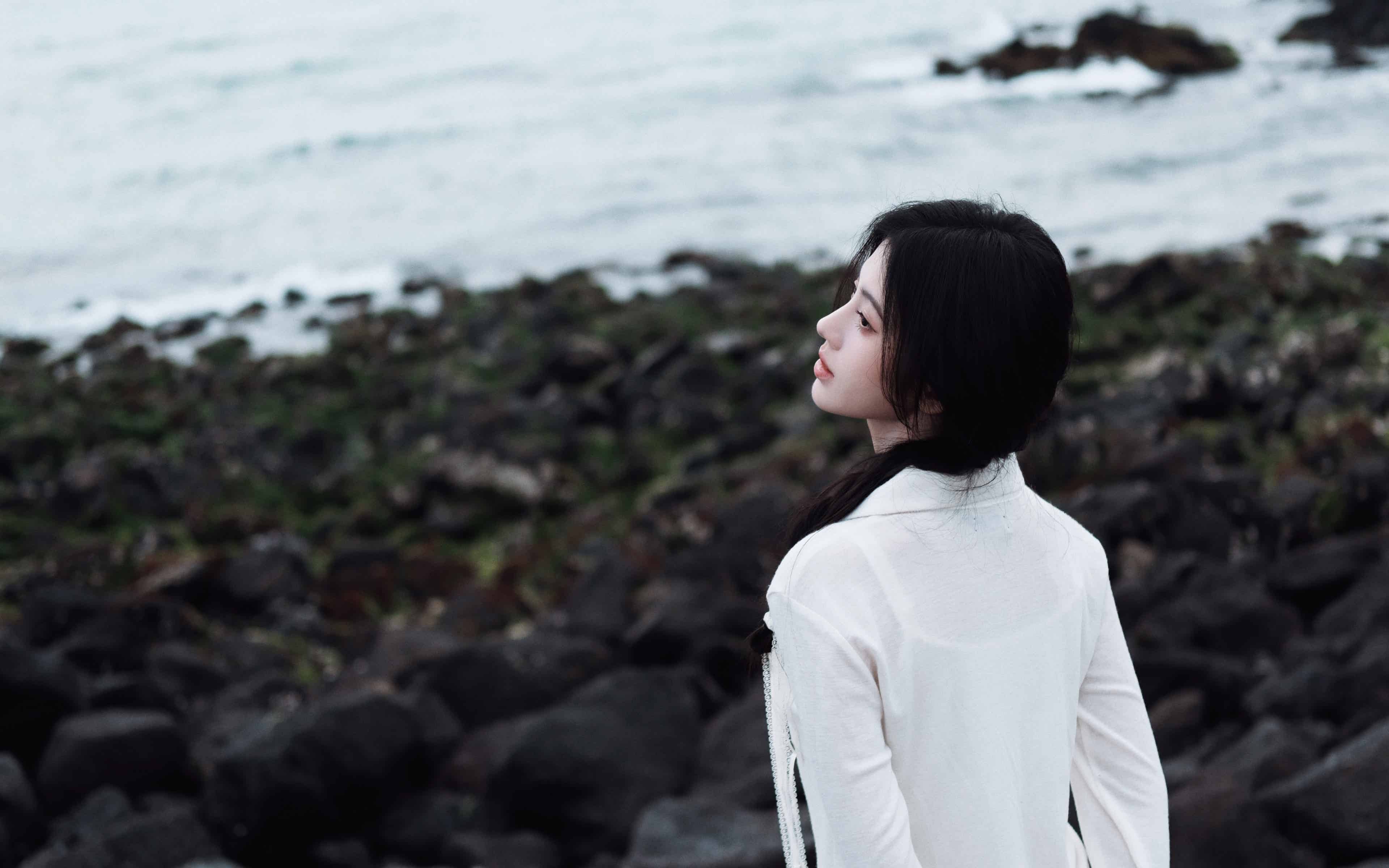 海边礁石上的白衣少女